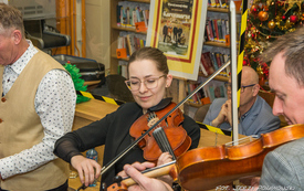 Grupa muzyk&oacute;w występuje przed publicznością grając na instrumentach takich jak: skrzypce, cymbały, akordeon, wiolonczela. 