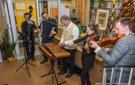 Grupa muzyk&oacute;w występuje przed publicznością grając na instrumentach takich jak: skrzypce, cymbały, akordeon, wiolonczela. 