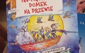 Okładka książki &quot;143 piętrowy domek na drzewie&quot; oraz logo DKK.