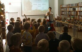 Dzieci słuchające prelekcji bibliotekarki.