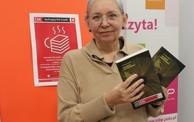 Bibliotekarka trzyma w rękach książki &quot;Trudno powiedzieć&quot; Łukasza Lamży. 