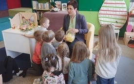 Bibliotekarka pokazuje dzieciom książkę. 