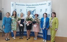 Grupa siedmiu kobiet pozuje na stojąco do wsp&oacute;lnego zdjęcia