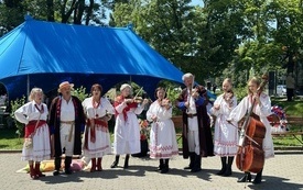 Kapela w strojach ludowych, z instrumentami podczas występu. 