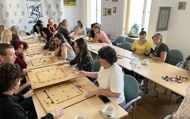 Na stołach drewniane plansze. Bibliotekarze grają w grupach. 