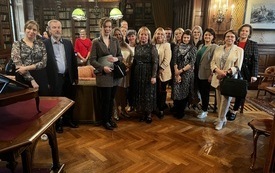 Zdjęcie grupowe uczestnik&oacute;w konferencji we wnętrzu zabytkowej biblioteki zamkowej. 