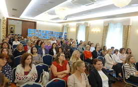 Grupa bibliotekarzy siedzi w sali konferencyjnej. 