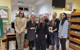 Zdjęcie grupowe bibliotekarzy, gościa oraz uczestnik&oacute;w spotkania.