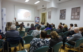 Uczestnicy spotkania w sali konferencyjnej. Profesor przemawia.